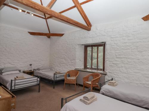 a room with two beds and a table and chairs at Brimpts Barn in Yelverton