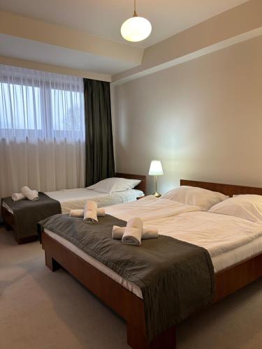 a bedroom with two beds with towels on them at Hotel Vesta Centrum Konferencyjno Wypoczynkowe in Jeleśnia