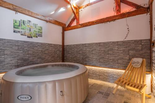 bañera de hidromasaje en una habitación con banco de madera en Luxury Vineyard Retreat Matej - Happy Rentals, en Trebnje