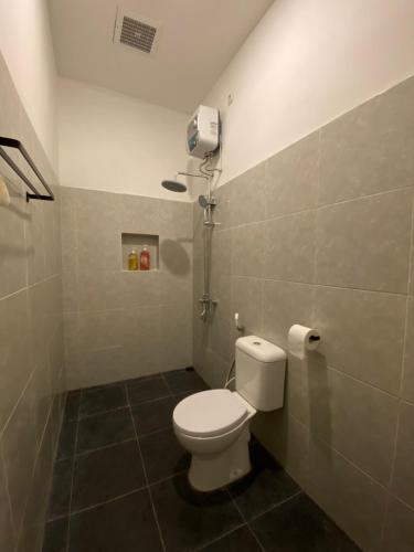 a bathroom with a toilet and a shower at Sare Living Homestay in Timuran