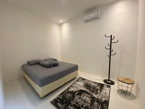 ein Schlafzimmer mit einem Bett in einem weißen Zimmer in der Unterkunft Sare Living Homestay in Timuran