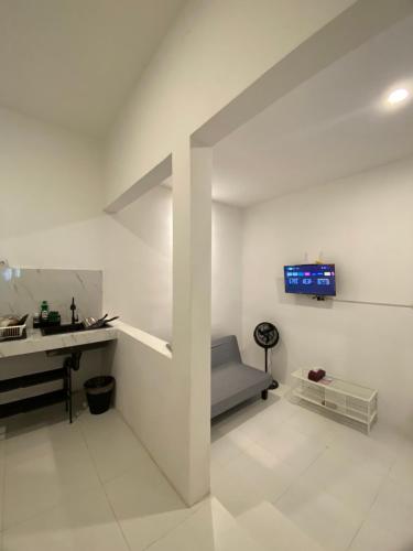 a white room with a sink and a desk at Sare Living Homestay in Timuran