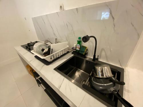 a kitchen counter with a sink and a stove at Sare Living Homestay in Timuran