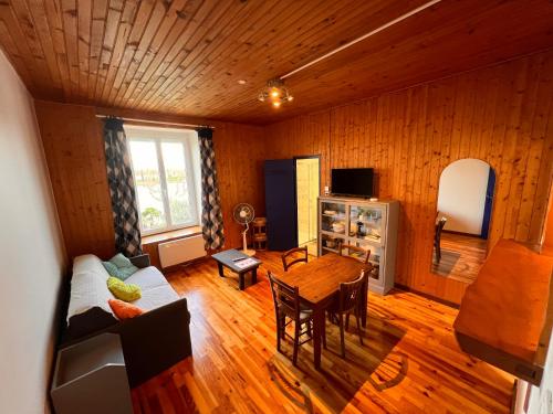 ein Wohnzimmer mit einem Sofa und einem Tisch in der Unterkunft Le gite des mariniers in Saint-Pierre-de-Boeuf