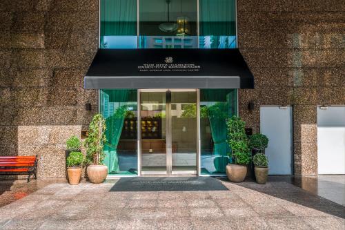 uma frente de loja com um toldo preto e vasos de plantas em Ritz Carlton Residences DIFC Downtown Dubai no Dubai