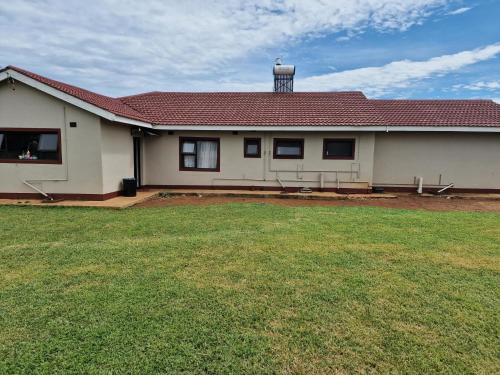 a house with a grass yard in front of it at Inviting 3-Bed House in Bulawayo in Bulawayo