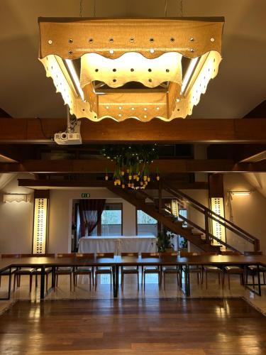 a dining room with a table and a chandelier at Hotel Vesta Centrum Konferencyjno Wypoczynkowe in Jeleśnia
