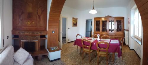 a dining room with a table and a fireplace at Casa Romme in Tornolo