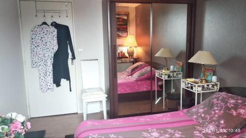 シェルブール・アン・コタンタンにあるChambre Rafaël chez particulierのベッドルーム(鏡、ベッド1台付)、ドレッシングルームが備わります。