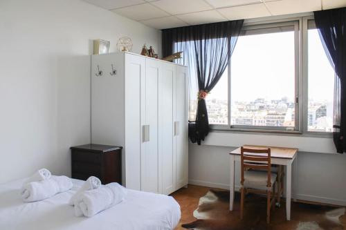 una camera con 2 letti, un tavolo e una scrivania di Balcony, 2 Rooms, View of Eiffel Tower, 60m² a Boulogne-Billancourt
