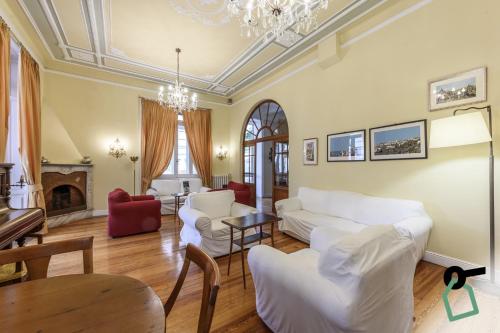 a living room with white furniture and a chandelier at HOTIDAY Hotel Rapallo in Rapallo