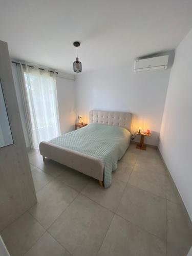 1 dormitorio con 1 cama en una habitación blanca en Lakaz Titi, en La Possession