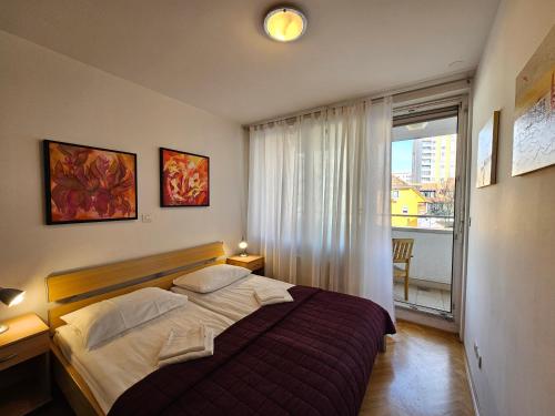 um quarto com uma cama grande e uma janela em Apartment Irena Tour As Ljubljana em Ljubljana