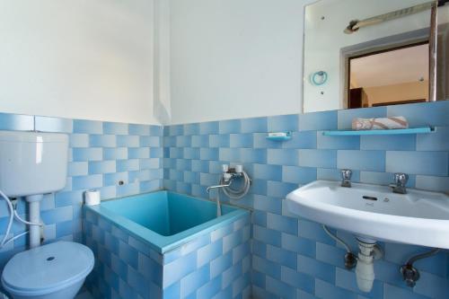 a blue bathroom with a toilet and a sink at Khumbila Hotel in Kathmandu
