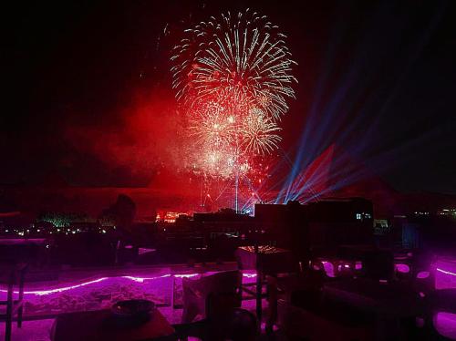 a firework display at night with chairs in the foreground at Pyramids MAGIC INN in Cairo