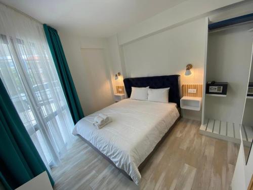 a bedroom with a large white bed and a window at Sunny Beach Potos in Potos