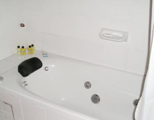 a white bath tub with a black faucet at Terrazas de Colón in Colón