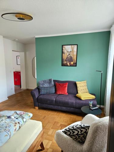 ein Wohnzimmer mit einem lila Sofa und bunten Kissen in der Unterkunft Schorn³ Appartements in Zell an der Mosel