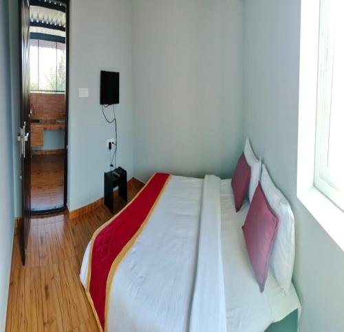 1 dormitorio con cama blanca y almohadas moradas en JK Resort en Yercaud