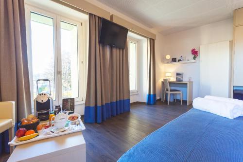 um quarto com uma cama e uma mesa com uma bandeja de comida em Hotel La Longeraie em Morges