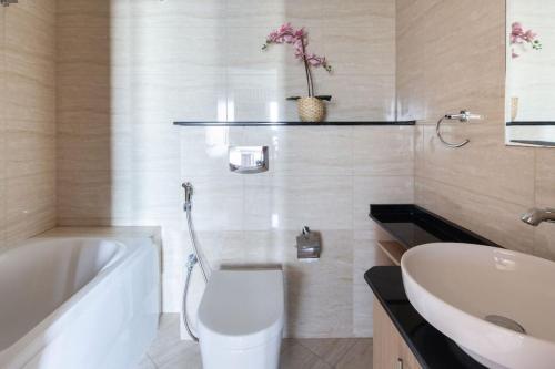 a bathroom with a tub and a toilet and a sink at Frank Porter - Ocean Heights in Dubai