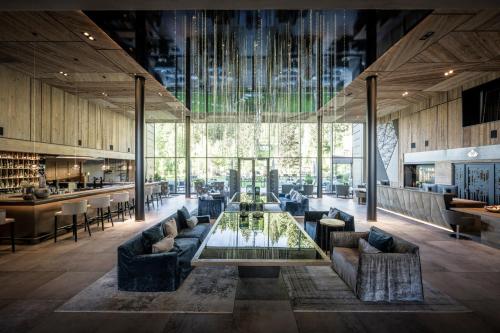 - un salon avec une table en verre et des canapés dans l'établissement Alpine Spa Resort Viktoria, à Avelengo