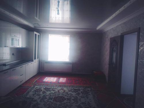 cocina con ventana y alfombra en el suelo en Ak-Tal guesthouse, en Akkyya