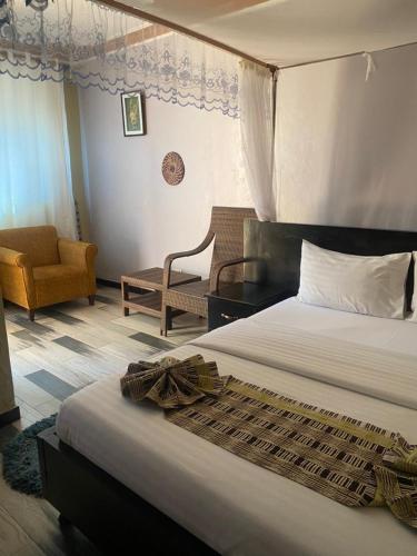 a hotel room with a bed and a chair at Life Lounge Guest house in Mbarara