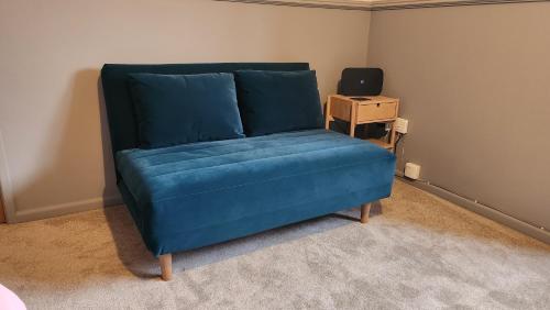 a blue couch in a room with a table at Dean Edge in Cinderford