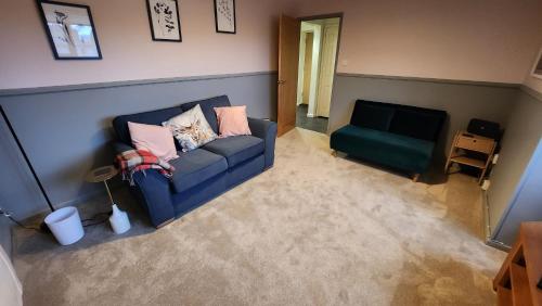 a living room with a blue couch and a chair at Dean Edge in Cinderford
