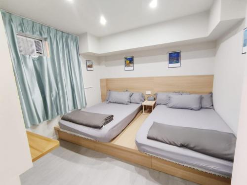 a bedroom with two beds and a window at The Nap Tsim Sha Tsui in Hong Kong