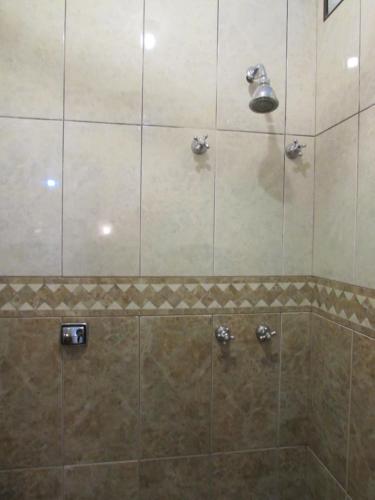 uma casa de banho com um chuveiro e uma porta de vidro em Hotel Paramount - São Paulo - Próximo a 25 de Março, Brás e Bom Retiro "Garanta já sua hospedagem" em São Paulo