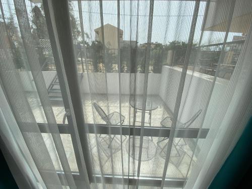 a view of a patio with tables and chairs through a window at Sunny Beach Potos in Potos