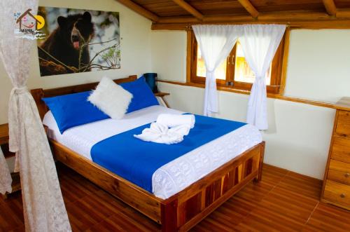 a bedroom with a bed with blue and white sheets at La Casa en el Aire Mindo, 4 Dormitorios in Mindo