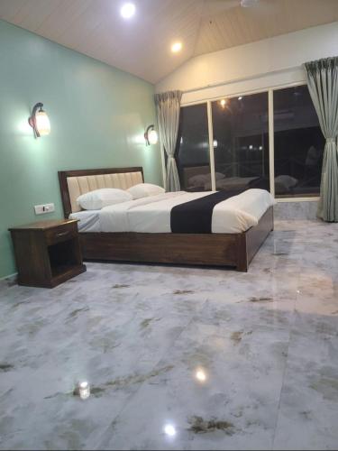 a large bedroom with two beds and a large window at 4D's Coast,Vagator in Vagator