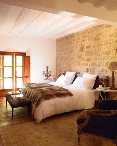 a bedroom with a large bed and a stone wall at milenyum travel in Şile