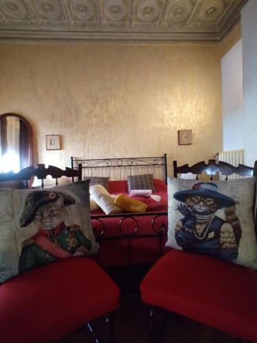 a bedroom with two beds and two red chairs at B&B Amarantha Gothica Genoa in Genova