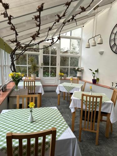 a dining room with tables and chairs and windows at The Spinney in Barnstaple