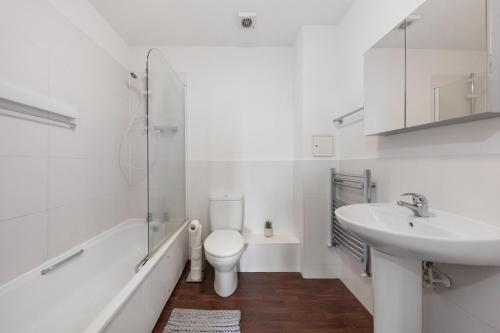 een witte badkamer met een toilet en een wastafel bij Deluxe 3 bed spacious & central next to station in Londen