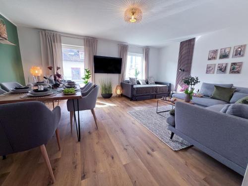 a living room with a couch and a table at UPPER ROOM Apartment im Zentrum mit kostenfreiem Parkplatz in Neustadt an der Weinstraße