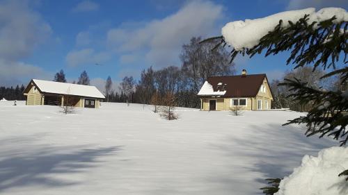 Ein Haus auf einem Feld mit Schnee darauf in der Unterkunft Põhjakalda in Nüpli
