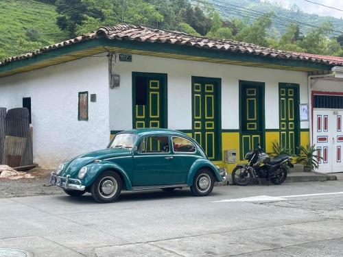 a green car parked in front of a house at BOSQUE DE NIEBLA in Pijao