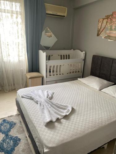 a bedroom with a white bed and a crib at Red White House in Antalya