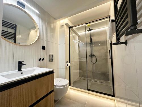 a bathroom with a shower and a toilet and a sink at Chrobry by Baltic Home in Międzyzdroje