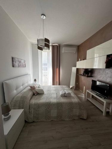 a white bedroom with a bed and a television at Bella Puglia Bed and Breakfast in Ruvo di Puglia