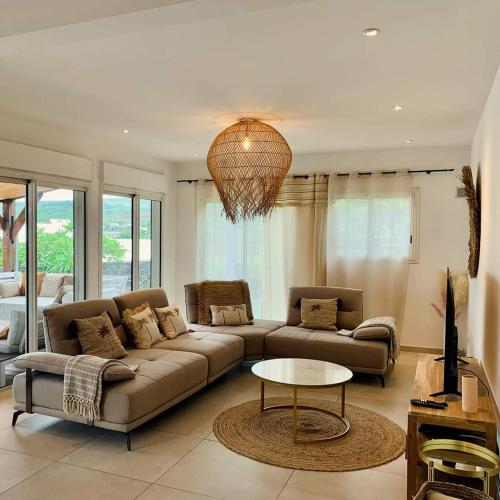 a living room with a couch and a table at Villa Rosa Palma 10 personnes piscine chauffée à St Gilles les bains in Saint-Paul