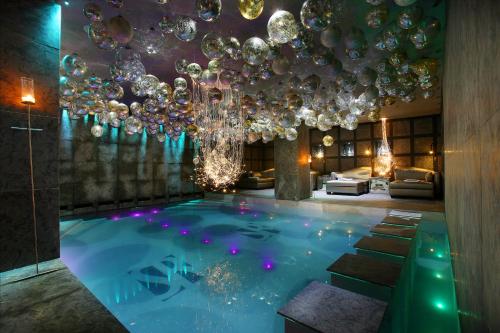 Cette chambre dispose d'une piscine avec un lustre. dans l'établissement Hotel Le Saint Roch, à Courchevel