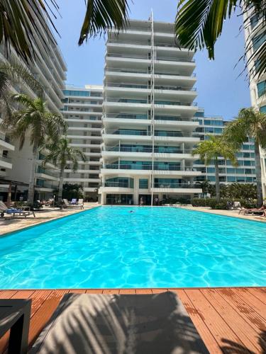 a swimming pool in front of a tall building at Playa Boquilla - Boquilla Beach - Apto con servicios de Hotel Sonesta in Cartagena de Indias