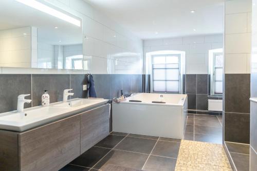 a large bathroom with two sinks and a tub at Gutshof-Penthouse-Wohnung- Seeblick in Klein Upahl