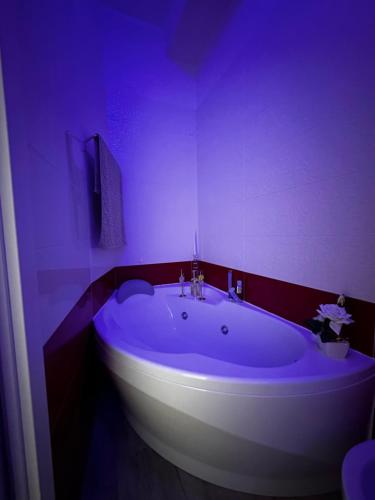 a bathroom with a large tub in a purple room at La Dimora degli Artisti in Pescara